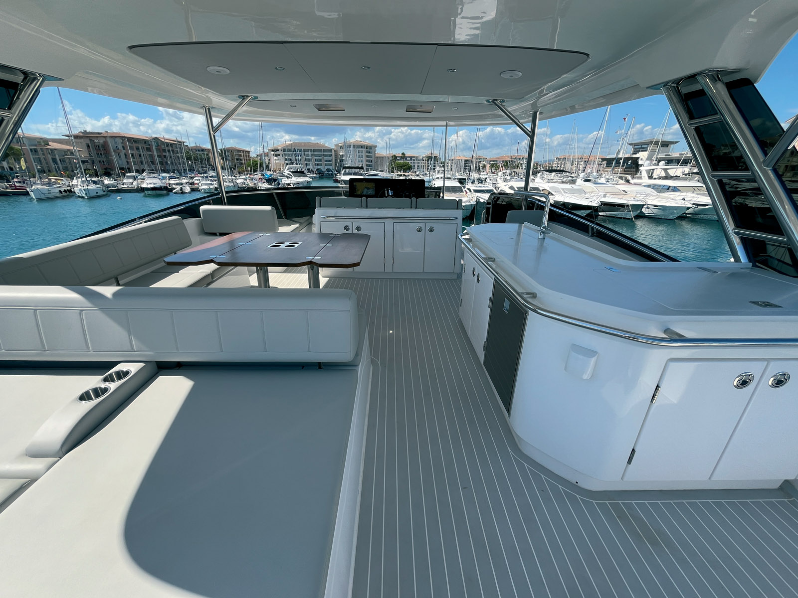 Grâce aux deux accès au fly décalés à tribord, le poste de pilotage a pu être avancé, créant derrière un espace immense pour les repas et le bain de soleil. Notez les porte-gobelets sur le dossier.