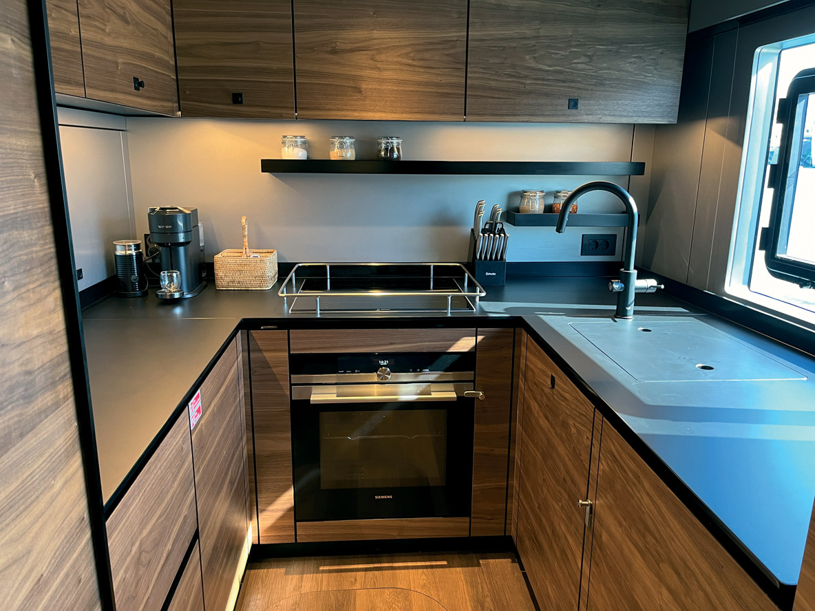 La cuisine est installée dans la coque tribord. En face se trouve une cabine double qui peut faire office de quartier d’équipage.