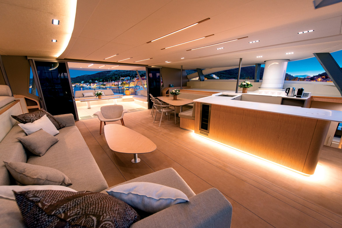 Dans la nacelle prennent place le salon, le carré et la cuisine de pont. Notez les carénages qui hébergent les mâts rotatifs et rétractables.