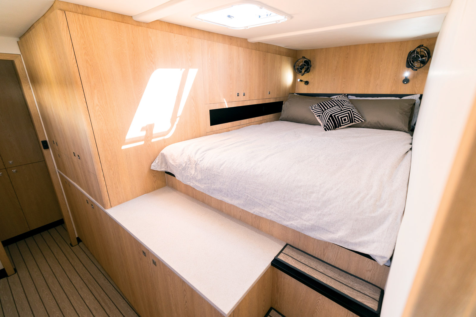 La cabine invités, située à l’avant bâbord, est équipée d’un lit queen-size offrant une grande hauteur sous plafond. Notez également le grand nombre de rangements.