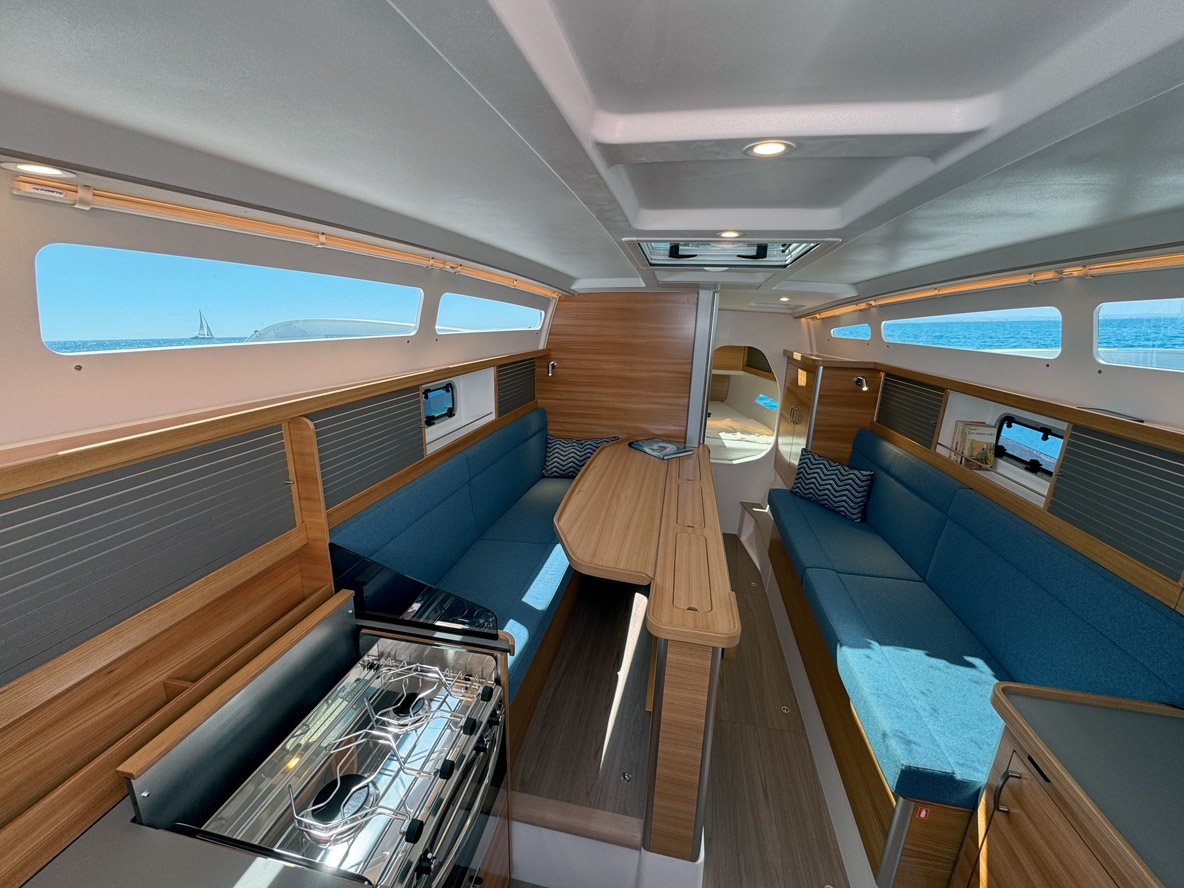 Le carré, quand la table à abattants est installée, occupe toute la largeur disponible. Pour la nuit, il est possible de mettre en place un couchage invité sur bâbord.