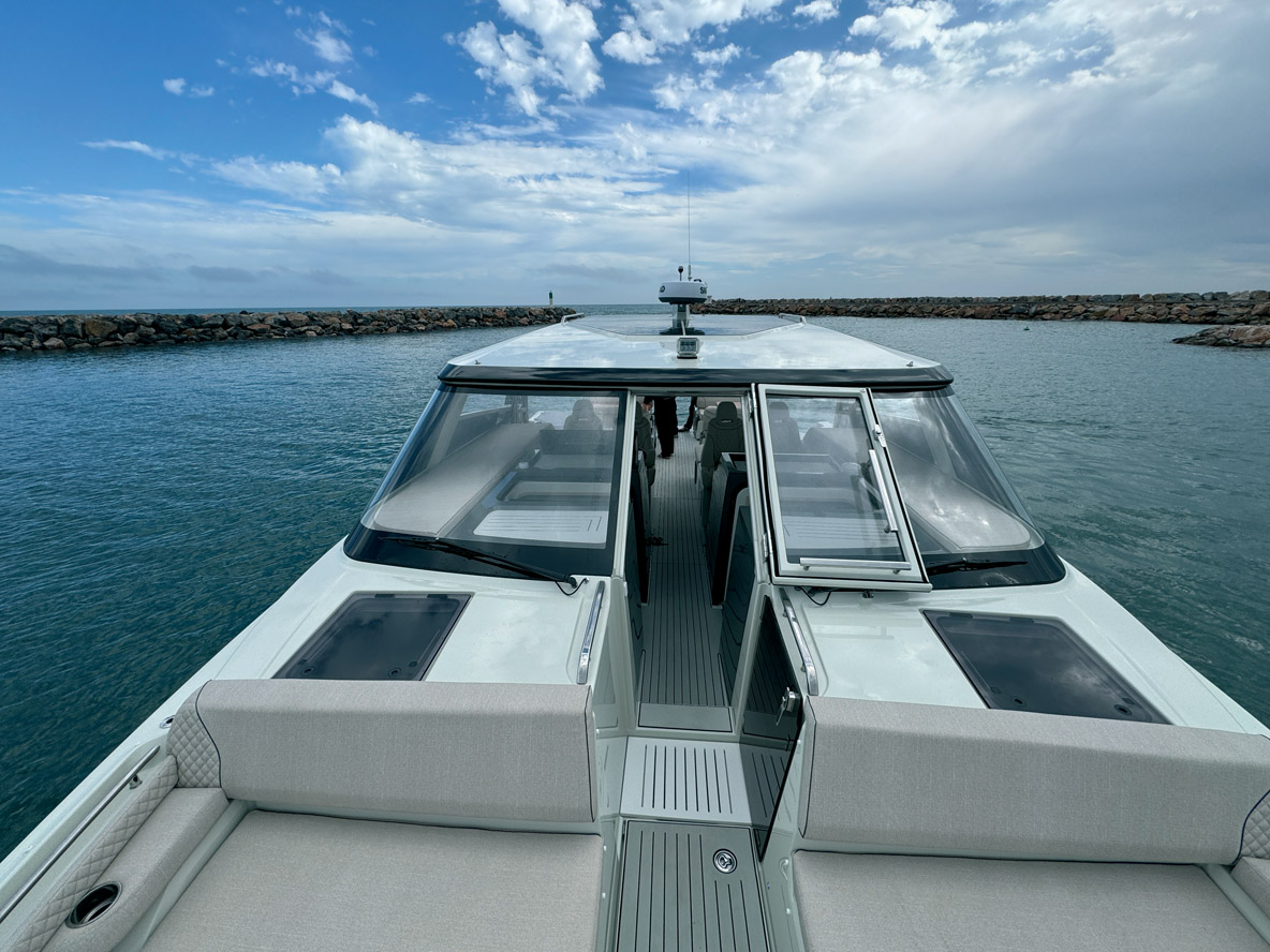 Le pontage avant de type bowrider se résume à un passage central, lequel dessert les immenses solariums et les apparaux de mouillage. Notez la présence de nombreuses mains courantes et les taquets rétractables. La porte avant se révèle un peu lourde à manipuler.