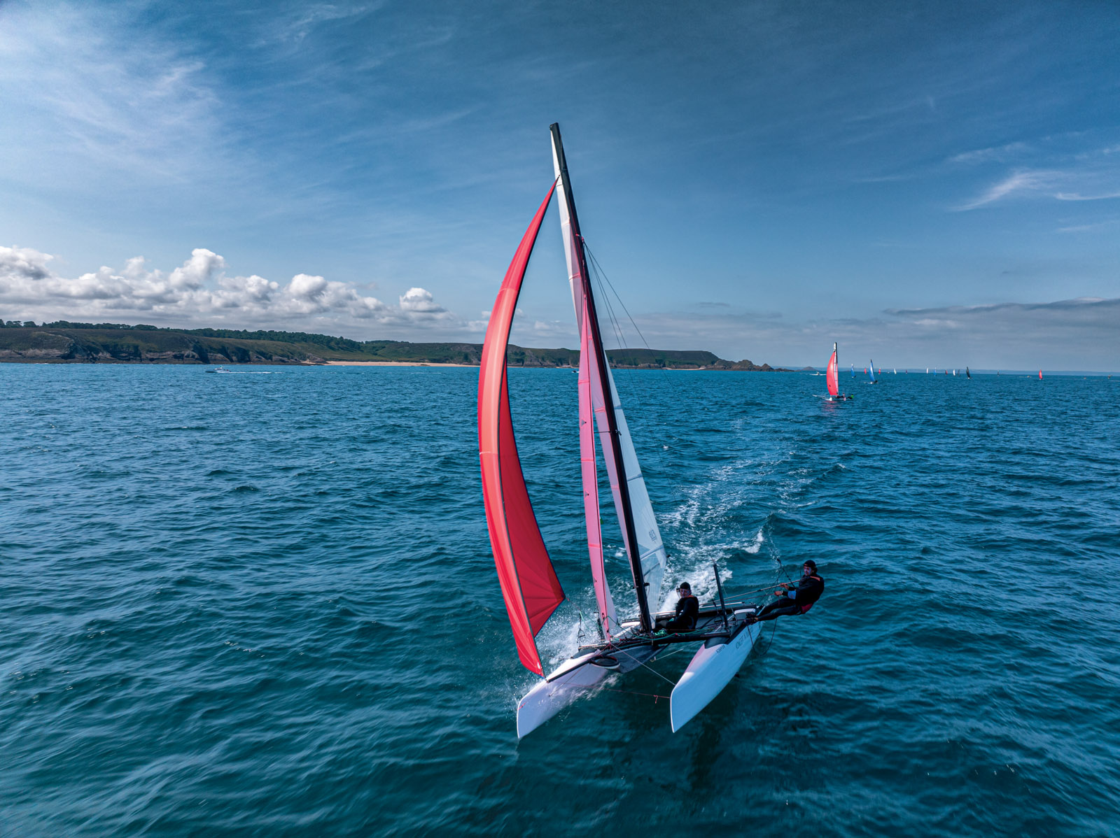A bord des Formule 18, les spis sortent très tôt des avaleurs (visible ici devant le mât,  un peu à bâbord du bout-dehors.)
