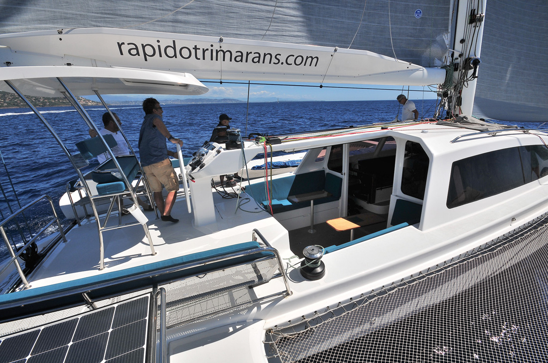 Une ergonomie très innovante ! Navstation surélevée, sièges banquette 4-6 places, siège de barre biplace rabattable. Observez la console piano avec les gros Lewmar 60 électriques placée sur le bimini et les larges oreilles de bôme. La cloison de cockpit est en position relevée sous le bimini.