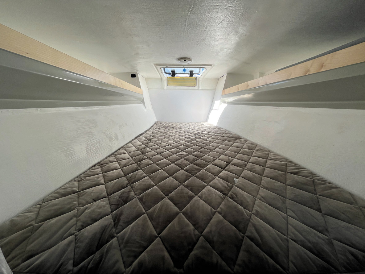 Une couchette un peu juste pour deux se glisse sous le cockpit ; on y accède en faisant pivoter l’échelle de descente.