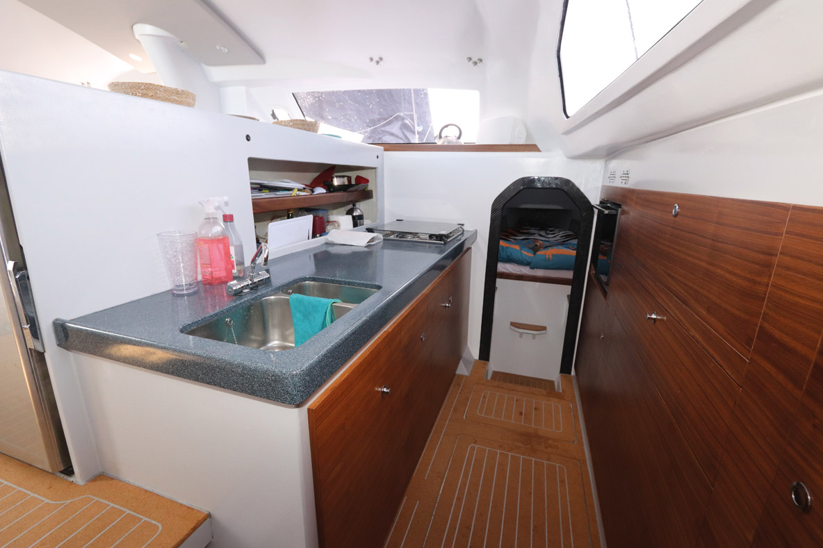Le rouf déborde sur les coques, dévoilant un espace inédit pour la  cuisine – cette disposition, qui date des tout premiers catamarans anglais, est conservée ici, et se révèle tout à fait convaincante.