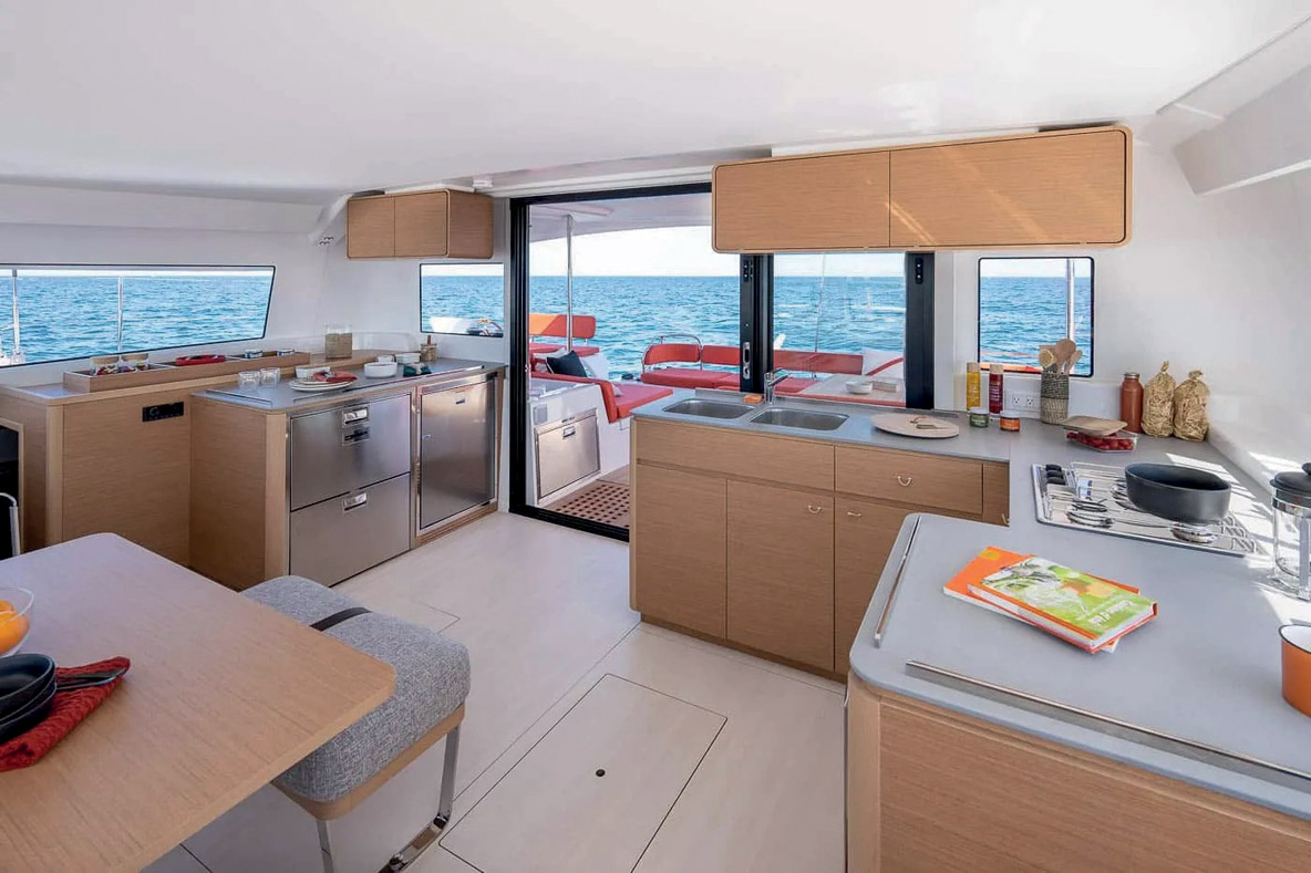 La cuisine occupe différents modules ; au total, la surface des plans de travail est importante et les meubles de rangement nombreux et bien pensés – à l’image des placards suspendus.