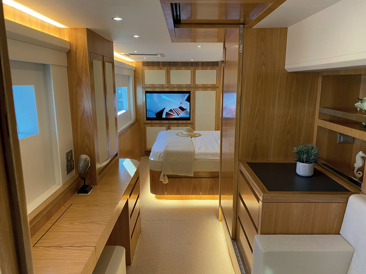 La grande cabine Propriétaire occupe toute la coque tribord, elle accueille un lit queen size en îlot et un dressing dans sa partie arrière pour atténuer le bruit du moteur. Le long bureau est baigné de lumière naturelle grâce à des hublots et des panneaux de pont assurant une bonne ventilation.