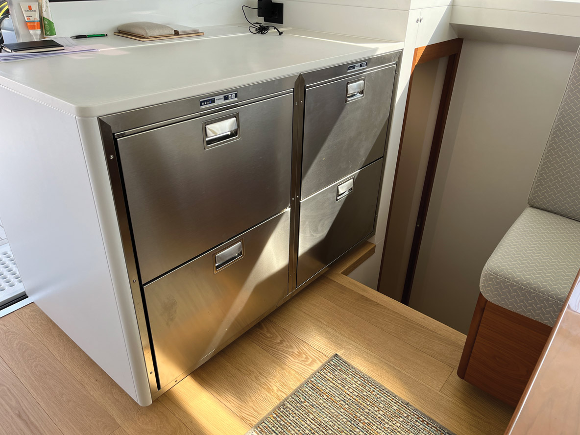 Sur tribord, la cuisine est traitée sérieusement avec un très grand plan de travail. Sur l’autre bord, un module de frigo tiroirs permet d’entrevoir de belles navigations.