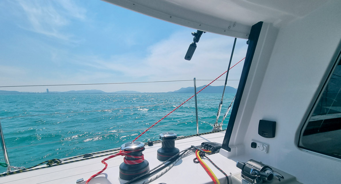 Le maniement des voiles peut se faire principalement depuis le cockpit, tandis que le toit rigide offre une bonne protection contre les intempéries.