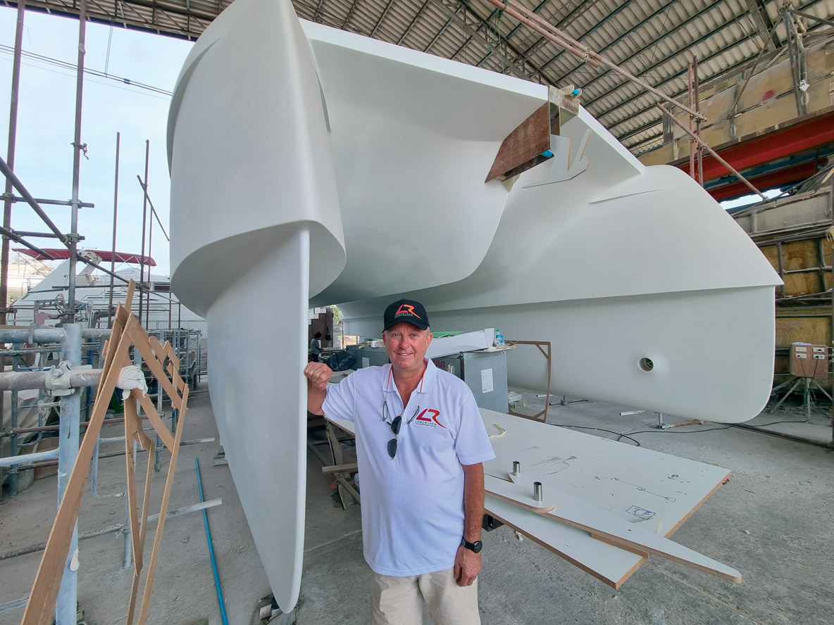 Andrew McLeod, directeur de Longreach, au chantier thaïlandais devant une coque en construction.