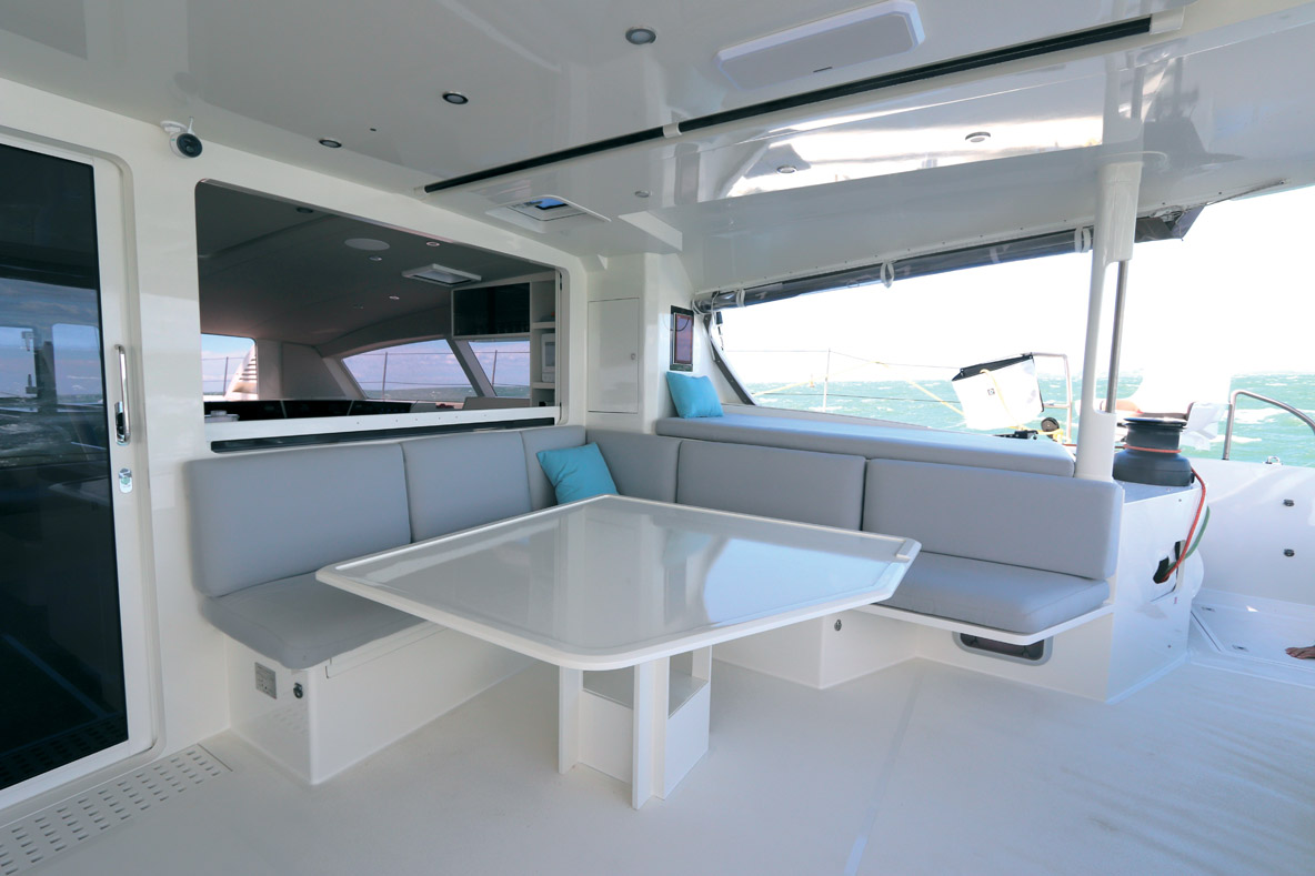 La table extérieure et ses banquettes sont bien protégées par le bimini.