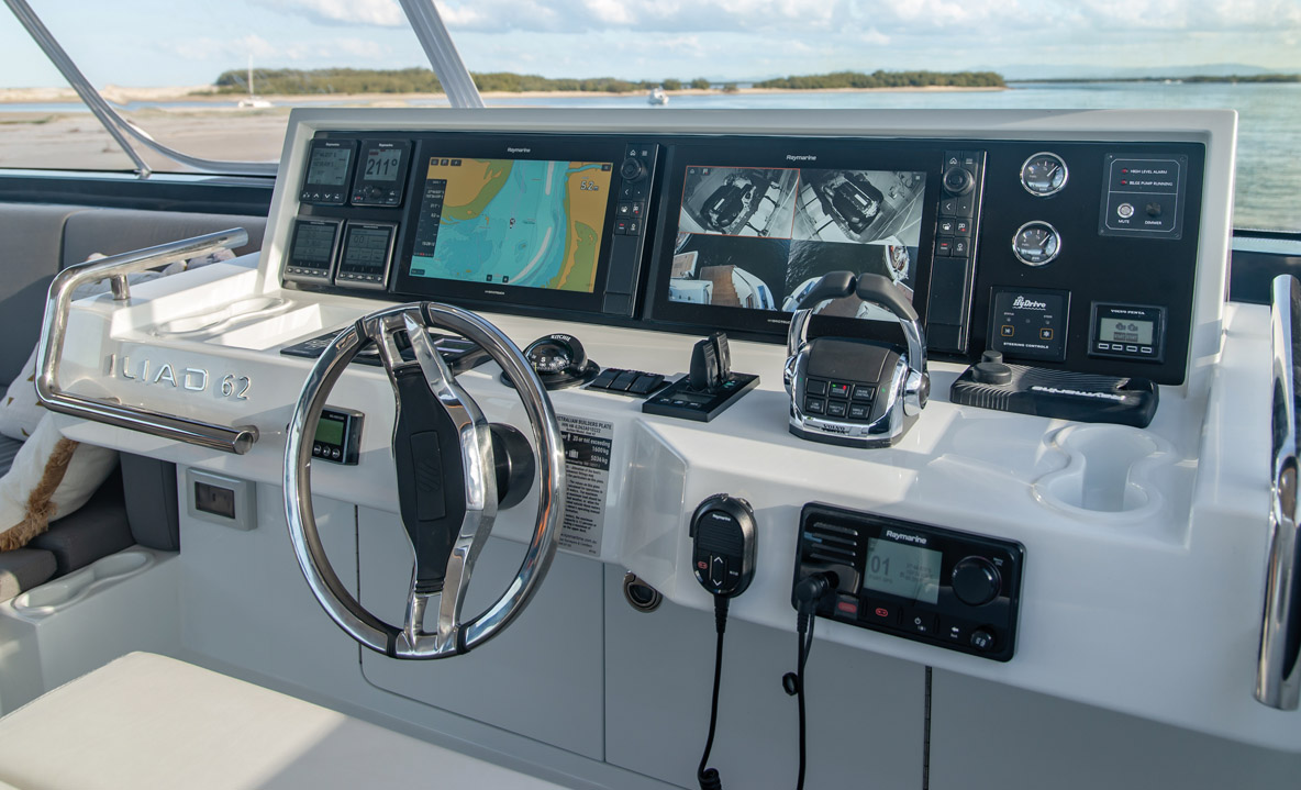 The flybridge steering console is well protected by the large fiberglass bimini and clear plastic covers that open by rolling them up. Clear instrumentation throughout  the Raymarine installation included autopilot, plotter and Volvo engine data.