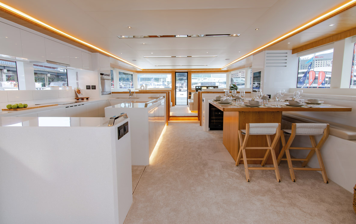 The saloon has vast volume from the vertical bulkheads and lots of floor space around the aft galley and forward lounge; with an exceptional standard of American Oak finish.