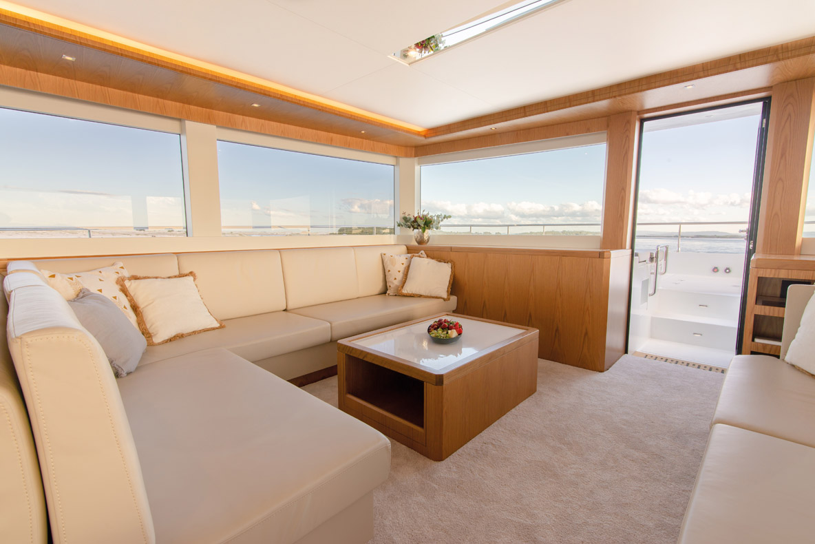 The elevated lounge in the saloon offers panoramic views and note the beautifully shaped dining table and surrounding wood finish.