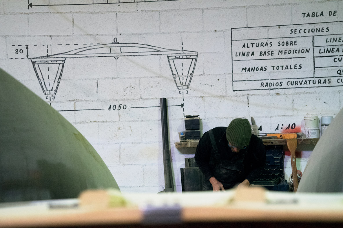 Dernières finitions avant la livraison de ce patin à voile. Sur le mur, on peut observer les mesures exactes d’un patin Junior.