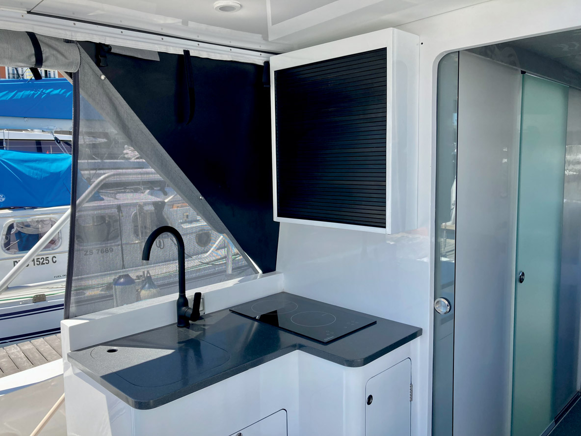 La cuisine est située dans le cockpit. Elle est bien équipée, avec une plaque à induction.