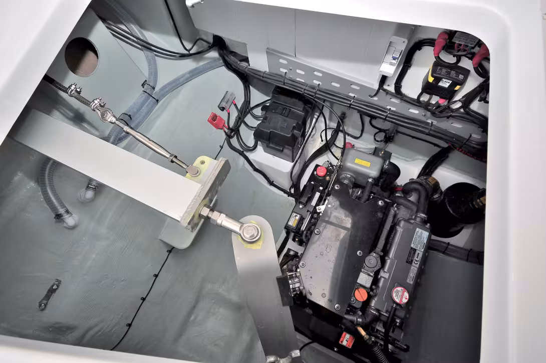 Une motorisation puissante clairement installée dans une cale lisible et propre (topcoat gris). Notez la biellette de liaison inter-safrans et les réglages de drosses de barre.