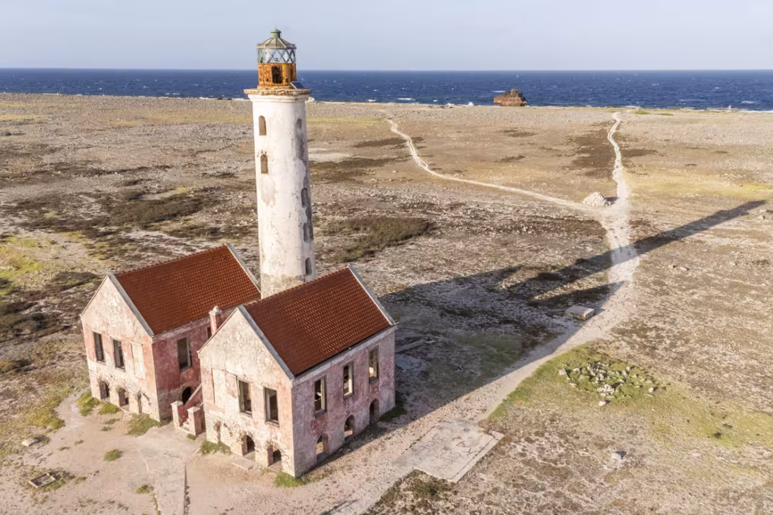 Non, ce n’est pas une roche qui se découpe sur  le rivage, mais bien une épave au pied du phare.